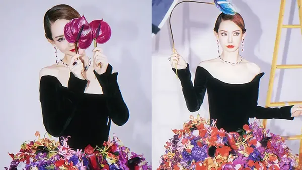 Qi Wei is surrounded by a group of flowers, bright and bright, holding a blue feather in her hand, and her expression is lively